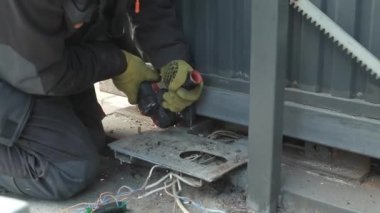 Metal tüpü Angle Grinder kullanarak kesen bir işçi. Parlak kıvılcımlar ve parıltılar
