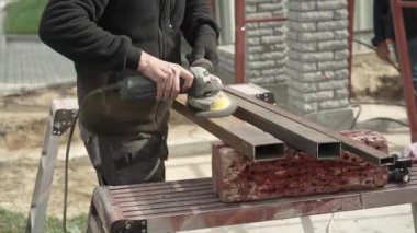 İşçi, Angle Grinder yapımı kullanıyor. Metal öğüten bir işçi. Pası çıkar. Parlak kıvılcımlar ve parıltılar