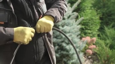 Elektrikçi, kabloyu koruyucu kıvrımlara yerleştirir. Elektrik kabloları için koruyucu kıvrım