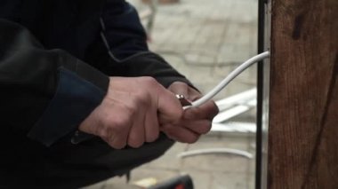 Elektrikçi elektrik kablolarının kurulumunu hazırlıyor. Elektrikçi kurulum için kablolar hazırlıyor