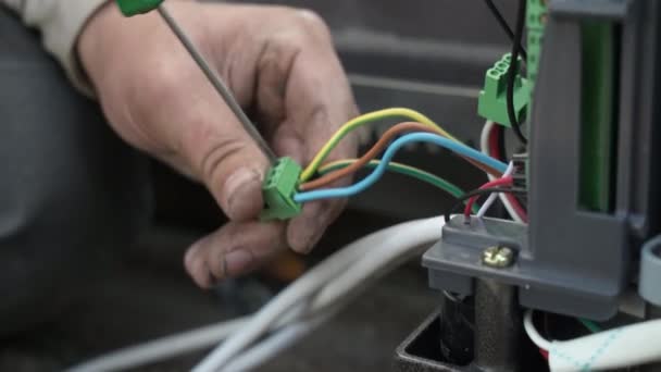 電気技師は コネクタを使用して 自動化および電子機器のワイヤーを接続するための配線を設置しています 電気機器の電線の接続について — ストック動画
