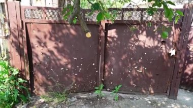 Metal kapı, Rus istilası sırasında bir füze saldırısından sonra hasar gördü. Rus ordusunun top atışından sonra garaj kapısında hasar. Rus-Ukrayna Savaşı