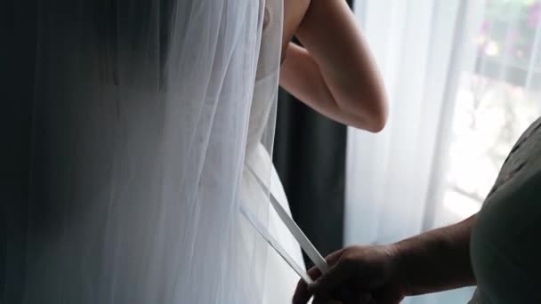 Koszorúslány Segít Fiatal Menyasszonynak Felvenni Esküvői Ruháját Nők Kezei Selyemszalagot — Stock videók