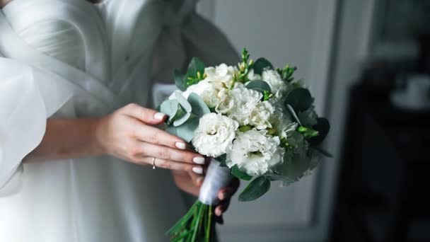 白いウェディングドレスの花嫁は イエストの結婚式の花束を保持しています 彼女の手で花束と花嫁の手のクローズアップ — ストック動画