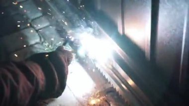 Kaynakçı metal bir boru kaynak yapar. Demir kaynaklama. Kaynak Kıvılcımları