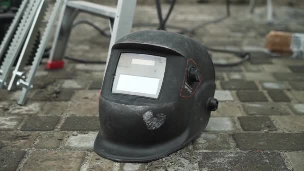 Black Welding Helmet Lies Concrete Tile Construction Site — Stock Video