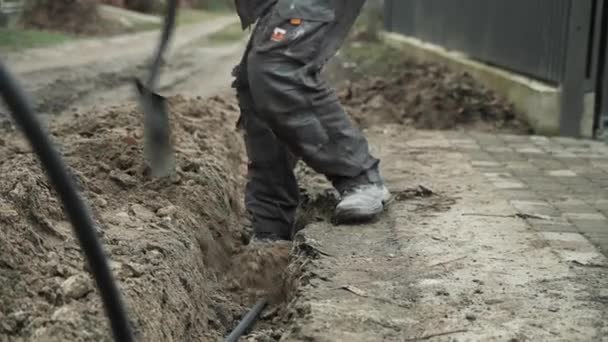 Arbetare Gräver Elektriska Ledningar Marken Med Skyffelman Gräver Ett Dike — Stockvideo