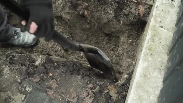 労働者はショベルマンで地面に電気ワイヤーを掘り シャベルで地面に溝を掘る — ストック動画