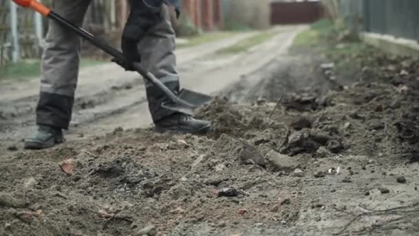 労働者はショベルマンで地面に電気ワイヤーを掘り シャベルで地面に溝を掘る — ストック動画