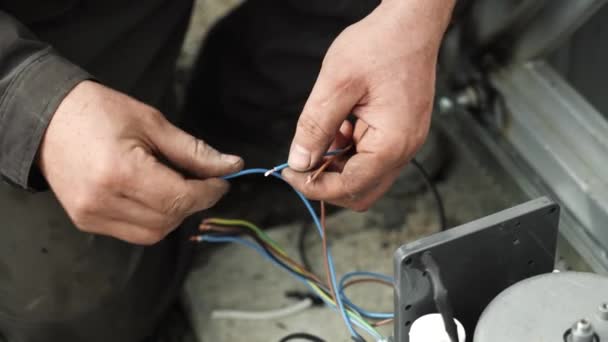 電気技師は コネクタを使用して 自動化および電子機器のワイヤーを接続するための配線を設置しています 電気器具の電線の接続について — ストック動画