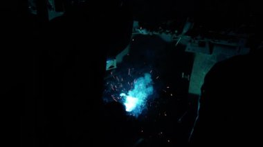 Kaynakçı metal bir boru kaynak yapar. Demir kaynaklama. Kaynak Kıvılcımları