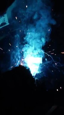 Kaynakçı metal bir boru kaynak yapar. Demir kaynaklama. Kaynak Kıvılcımları