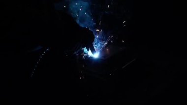 Kaynakçı metal bir boru kaynak yapar. Demir kaynaklama. Kaynak Kıvılcımları