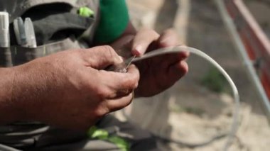 Elektrikçi, konnektörleri kullanarak kabloları otomasyon ve elektronik ekipmanlara bağlıyor. Elektrikli aletlerin elektrik kablolarının bağlantısı