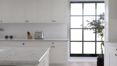 Geniş panoramik pencereli büyük beyaz mutfak. 3D animasyon. Beyaz çekmeceli mutfak, mutfak aletleri ve beyaz mermer..