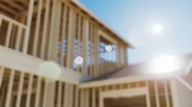 Çerçeve inşaatı. Yapım aşamasında olan ve geçmişi bulanık olan bir çerçevenin odaksız konsept videosu. Mavi gökyüzüne karşı ahşap kiriş ve duvar. 3d canlandırma