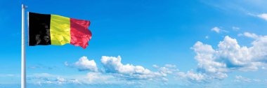 Belgium Flag - state of Europe, flag waving on a blue sky in beautiful clouds - Horizontal banner