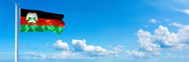 Afghanistan Flag (1980-1987), flag waving on a blue sky in beautiful clouds - Horizontal banner