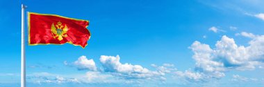 Montenegro Flag - state of Europe, flag waving on a blue sky in beautiful clouds - Horizontal banner