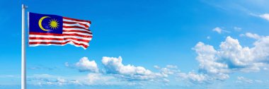 Malaysia Flag - state of Asia, flag waving on a blue sky in beautiful clouds - Horizontal banner