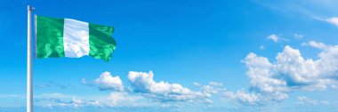 Nigeria Flag - state of Africa, flag waving on a blue sky in beautiful clouds - Horizontal banner