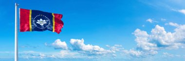 Mississippi flag - state of USA, flag waving on a blue sky in beautiful clouds - Horizontal banner