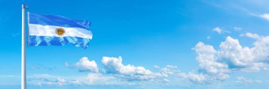 Argentina flag - state of America, flag waving on a blue sky in beautiful clouds - Horizontal banner