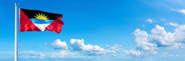 Antigua and Barbuda flag - state of America, flag waving on a blue sky in beautiful clouds - Horizontal banner