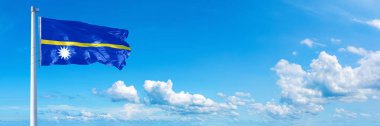Nauru Flag - state of Australasian, flag waving on a blue sky in beautiful clouds - Horizontal banner