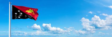 Papua New Guinea Flag - state of Australasian, flag waving on a blue sky in beautiful clouds - Horizontal banner