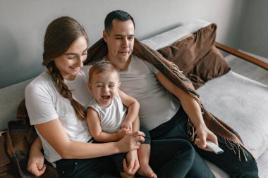 Genç ebeveynler ve oğulları Noel tatili boyunca birlikte vakit geçirmenin keyfini çıkarıyorlar. Anne, baba ve küçük çocuk rahat bir kanepede Noel ağacının yanında oturup birlikte televizyon izliyorlar. Kış tatili ve insanların konsepti