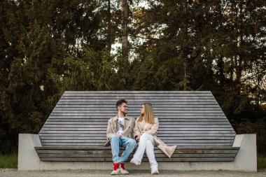 Güzel, şık, genç bir çift bankta oturuyor. Bir kadın ve bir erkek konuşuyor ve birlikte zaman ve bahar havasının tadını çıkarıyorlar.