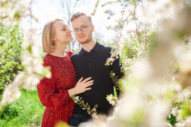 Birbirine aşık bir çift, güzel bahar havasından ve parlak güneşten zevk alıyor. Aile kavramı ve doğa ile birlik.