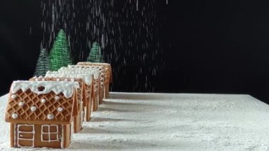 Gökyüzünden kar yağan ev yapımı zencefilli kurabiye evleri. Noel konsepti.