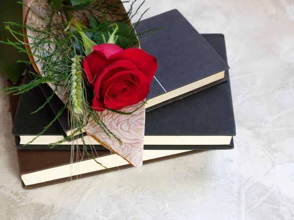 Stack of books and red rose with ear of corn, traditional Sant Jordi gift, Sant Jordi\'s day. Catalan version of Saint Valentine\'s Day
