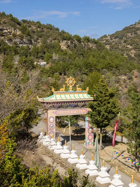 stock image view from above of the entrance gate to a Buddhist temple with the symbols, flags and stupas. Panillo, Spain.