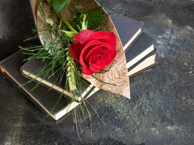 Stack of books and red rose with ear of corn, traditional Sant Jordi gift, Sant Jordi's day. Catalan version of Saint Valentine's Day clipart