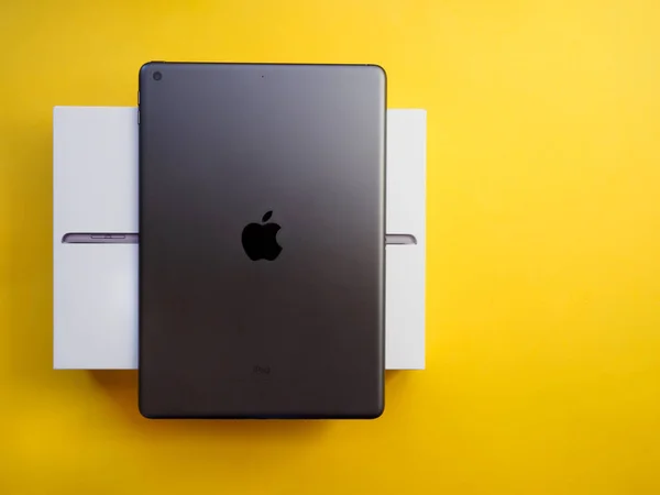 stock image Lleida, Spain - February 28, 2023 : Studio photo of the new gray Apple iPad, logo from rear view. Isolated on yellow background. Illustrative editorial content.