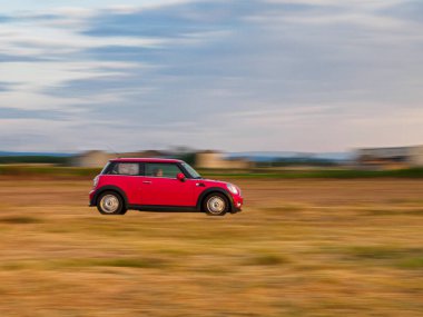 Lleida, İspanya. 21 Mayıs 2023. Red Mini Cooper son sürat yolda koşuyor. Hareket bulanıklığı olan arkaplan.