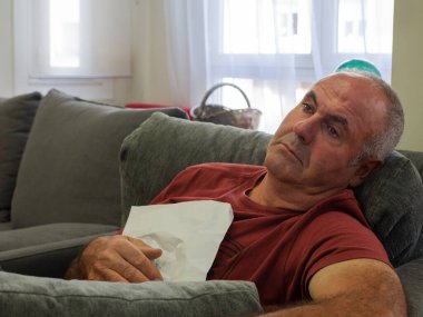 Yaşlı bir adam elinde bir mektupla kanepede tek başına oturup ağlıyor. Özlem kavramı.