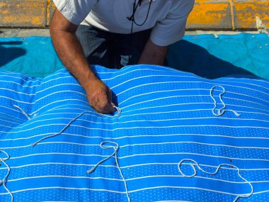 Yün bir yatağın içini yeni yün ile diken bir döşek imalatçısı..