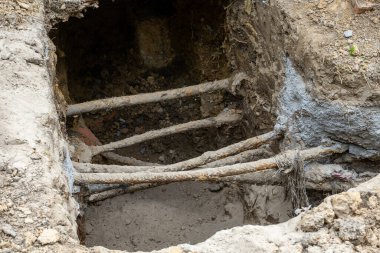 İnce paslı boruları olan bir hendek. Yeraltı güç hattı