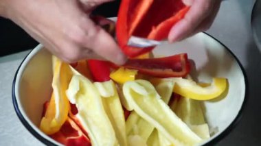 Aşçı bıçakla büyük tatlı biber öğütür.