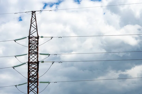 A support of a high-voltage electric line on a background of clouds.