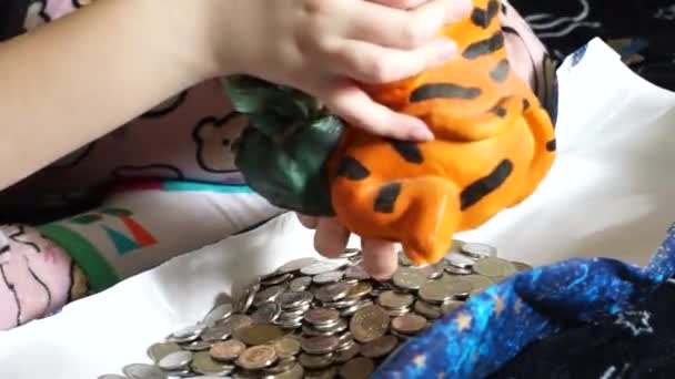 一个少年从明亮的橙色储蓄罐里取钱 — 图库视频影像