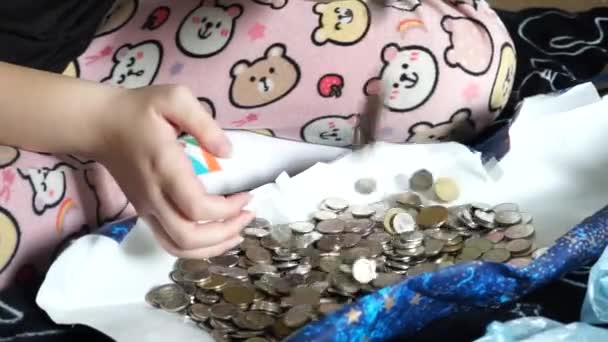 その子は宝に満足している 十代の女の子遊びます小さな金属のコイン — ストック動画