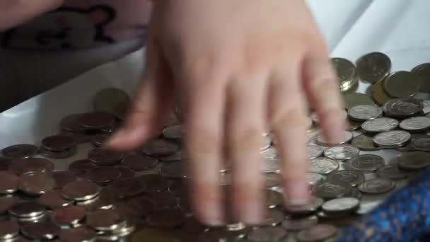 这个女孩用手对硬币进行排序 — 图库视频影像