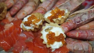 Deniz ürünleri yakın plan. Kırmızı havyarlı bir tabak, balık ve karides.