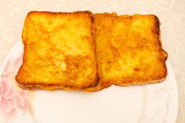 Çiçek tabağında altın sarısı Fransız tostu.