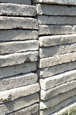 Parlak bir güneşe karşı yığılmış büyük beton levhalar..